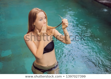 ストックフォト: Frustrated Young Woman Having A Bad Hair In The Pool Due To The Fact That Chemicals In The Pool