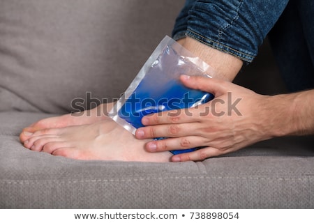 Zdjęcia stock: Holding Ice Gel Pack On Ankle