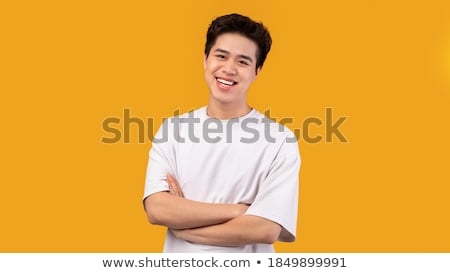 [[stock_photo]]: Portrait Of A Cheerful Asian Man Standing With Arms Folded Over White Background