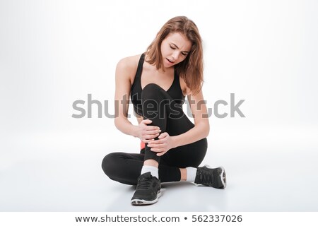 Foto stock: Sad Young Fitness Lady With Painful Holding Legs