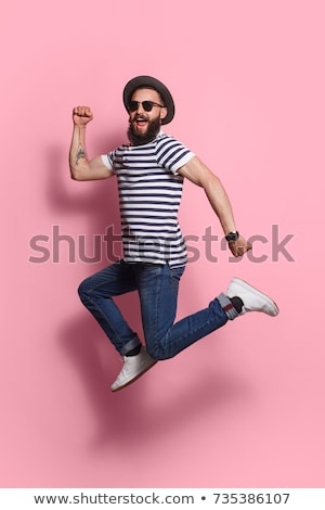 ストックフォト: Vertical Image Of Hipster Jumping In Studio