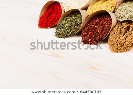 商業照片: Various Colorful Powder Seasoning Close Up In Paper Corners On White Wooden Board With Copy Space