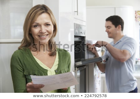 Foto stock: Satisfied Female Customer With Oven Repair Bill