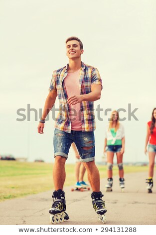 Foto stock: Roller Skating Boy With Friends In Town