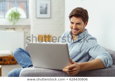 Сток-фото: Man Working On His Laptop At Home As He Relaxes On A Comfortable