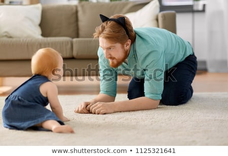 Foto stock: Father Wearing Cat Ears Headband Playing With Baby