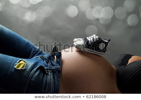 Stok fotoğraf: Pregnant Belly With Little Pink Shoes