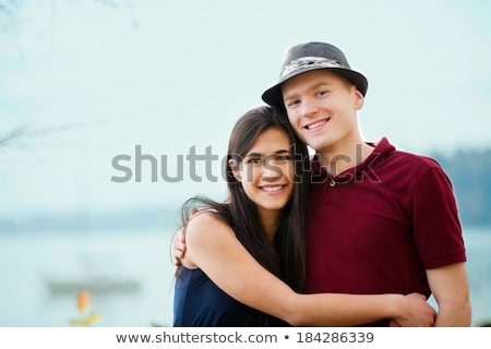 Foto stock: Young Interracial Couple Hugging By Lake