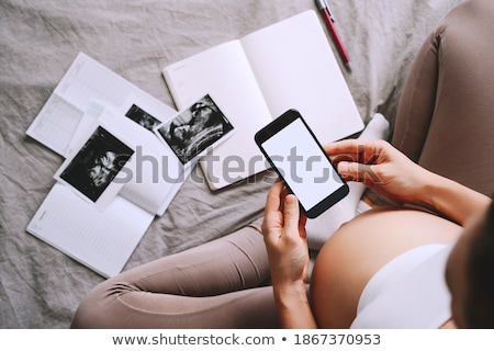 Foto stock: Pregnant Woman Displaying A Prenatal Ultrasound