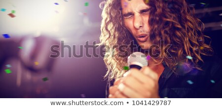 Foto stock: Male Musician With Eyes Closed Singing At Nightclub