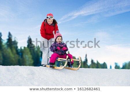 Stock foto: Mother Pushing Her Daughter On Sledge