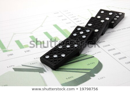 Foto d'archivio: Risky Domino Over A Financial Business Chart