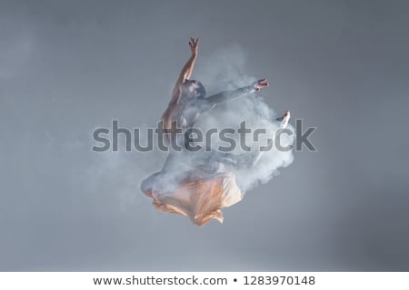 Stockfoto: Young Beautiful Dancer In Beige Dress Dancing On Gray Background