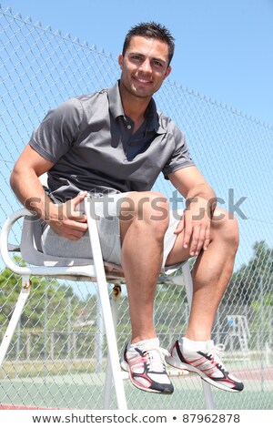 [[stock_photo]]: Smiling Friendly Tennis Umpire Sitting In The Sunshine