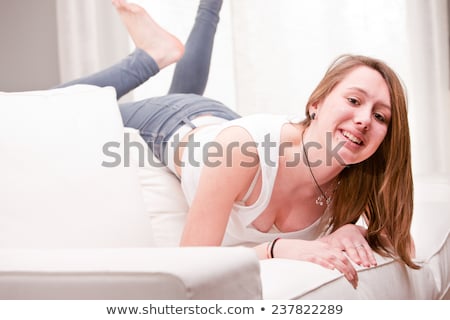 Foto d'archivio: Smiling Girl In A Strange Position On A Couch