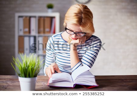 Businesswoman Reading Books In Office Stockfoto © Pressmaster