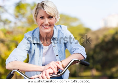 Stockfoto: Happy Senior Woman Riding Bicycle At Summer Park