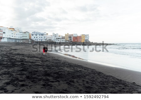 Stock photo: Couple In Love Walking On The Beach Near The Powerful Ocean With The Sunset In Puerto De La Cruz