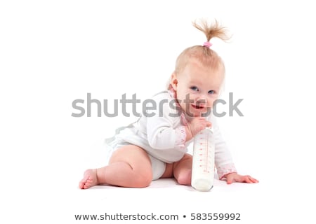 Foto d'archivio: Cute Happy Baby Girl In White Shirt Hold Bottle
