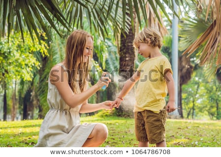 Foto stock: Mom And Son Use Mosquito Sprayspraying Insect Repellent On Skin Outdoor