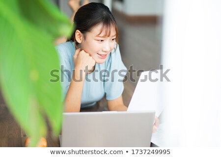 Stockfoto: Young Woman Smiling As She Reads The Morning Paper