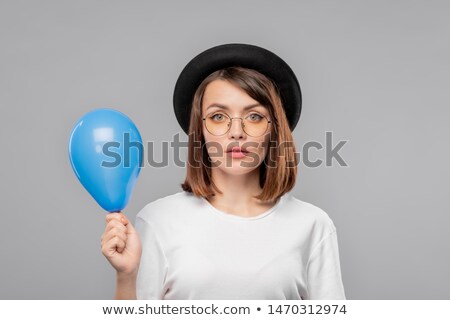 Pretty Serious Girl In Hat And T Shirt Holding Blue Balloon Stockfoto © Pressmaster