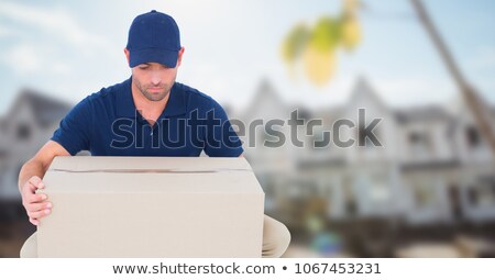 Foto stock: Delivery Man Picking Up Box Against Blurry Housing Estate