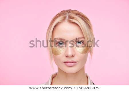 Сток-фото: Serious Young Blond Woman With Golden Revitalising Under Eye Patches