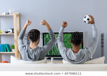 Foto d'archivio: Two Guys Watching Football On The Couch