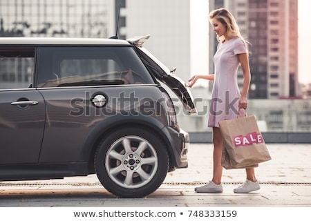 ストックフォト: Caucasian Woman Putting Her Shopping Bags Into The Car Trunk