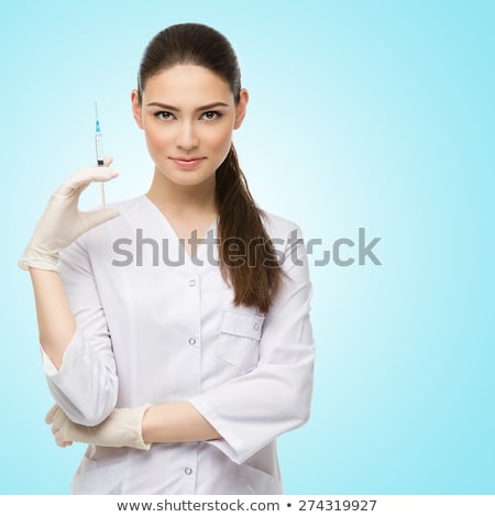 Zdjęcia stock: Beautiful Young Doctor In Medical Robe Holding Syringe With Liquid Isolated Over Blue Background