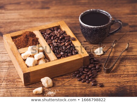 Stockfoto: Black Ceramic Cup Of Fresh Raw Organic Coffee With Beans And Ground Powder With Cane Sugar In Vintag