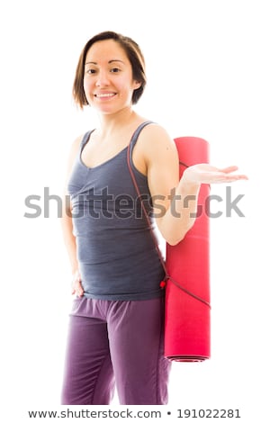 Foto d'archivio: Young Woman Carrying Exercise Mat Presenting Something And Smili