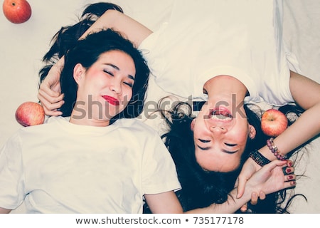 Stock fotó: Portrait Of Two Happy Women Wearing White Shirts On Bed