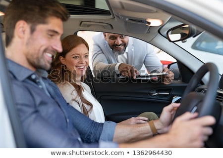 Сток-фото: Young Smiling Couple Testing A New Car While Sitting Inside