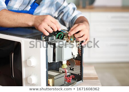 [[stock_photo]]: Male Technician Checking Microwave