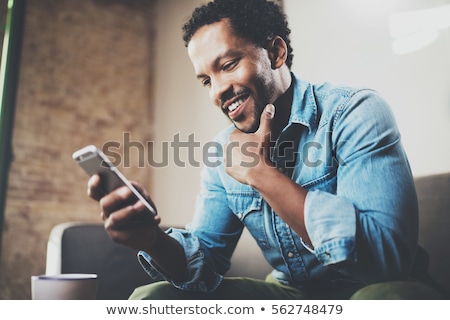 Foto d'archivio: Young Businessman Using Mobile Phone In Office