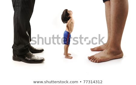 Foto d'archivio: Little Small Child Is Looking At The Giant Legs Of Two Men Businessman And Barefoot One