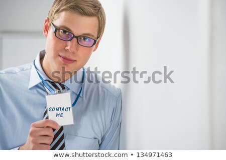 Foto d'archivio: Handsome Businessman Showing Contact Me Text On A Badge