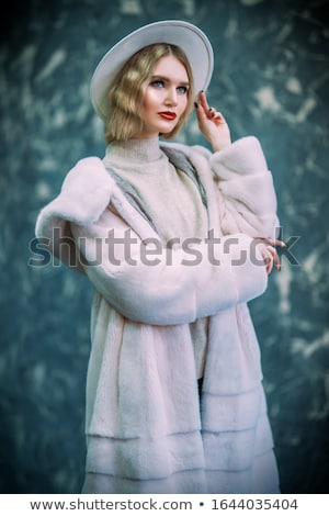 Stockfoto: Studio Portrait Of Young Woman Wearing Fur Hat And Coat