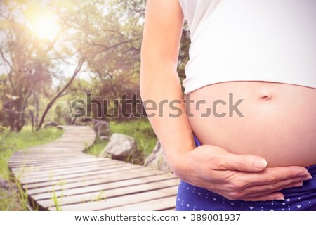 Stock photo: Pregnant Woman With Baby Shoes Over Bump