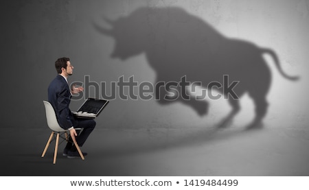 ストックフォト: Businessman Staying And Offering Stuffs To A Huge Bull Shadow