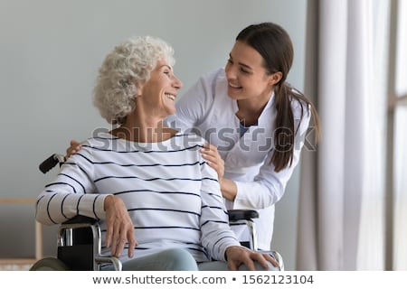 Stok fotoğraf: Happy Smiling Doctor Or Nurse Talking To Senior Woman In Chair A