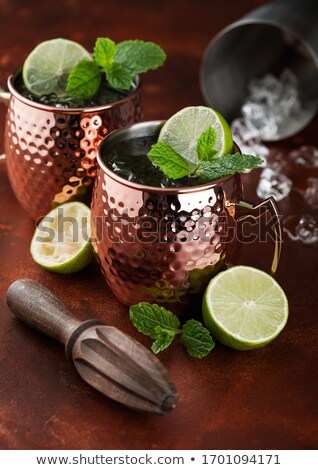 Stock photo: Moscow Mule Cocktail In A Copper Mug With Lime And Rosemary On Brown Background