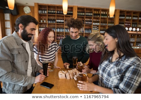 Stock foto: Friends Playing With Wooden Blocks While Having Glass Of Beer