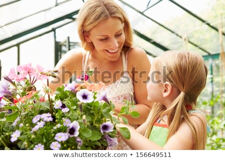 Foto stock: Mother And Daughter In Garden With Flower Basket