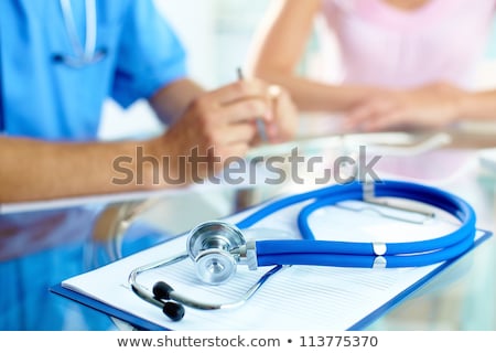 Stock fotó: Close Up Of Male Doctor And Patient With Clipboard