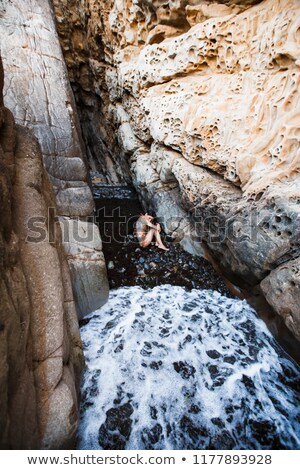 Foto d'archivio: Beauty Young Woman Among Rocks At Sea Dreaming Relaxing