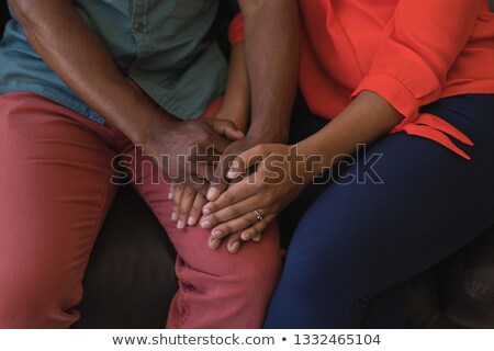 Foto d'archivio: Close Up View Of A Senior Couple Holding Hands While Sitting Together On Sofa In Living Room At Home