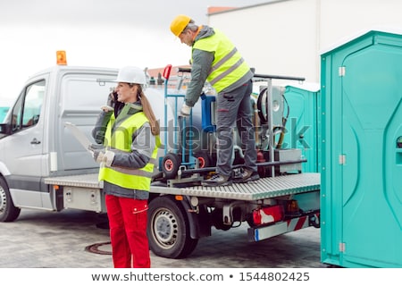 Stock fotó: Workers Taking Care Of A Delivery Of Mobile Rental Toilets